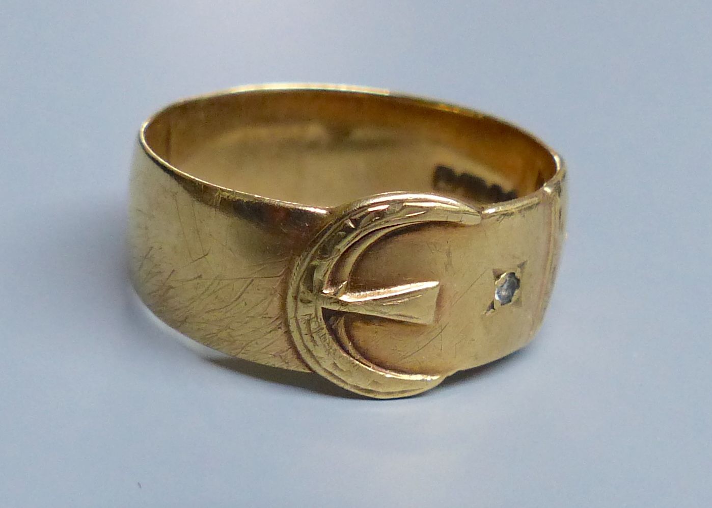 A modern 9ct gold and two white stone chip set buckle ring, size U/V, gross 5.1 grams.